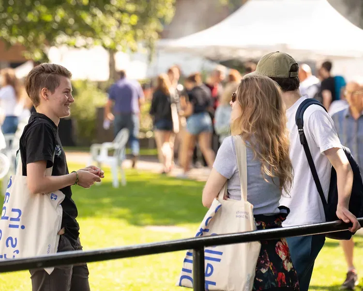 Three prospective standing outside during a sunny open day in august. 