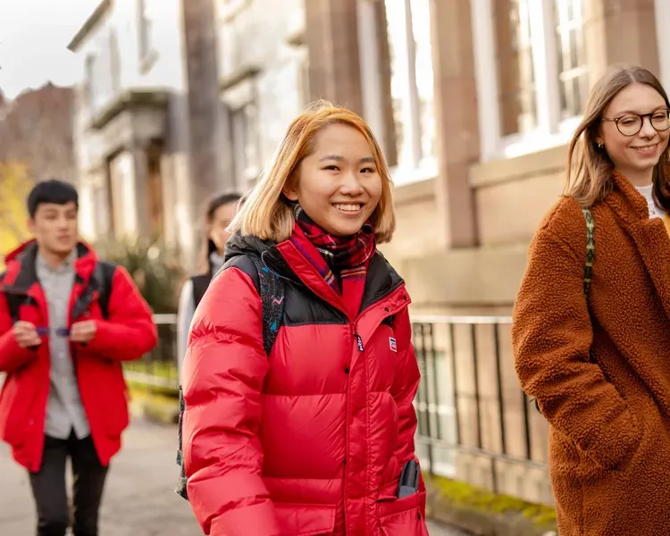 students walking in front of red brick building