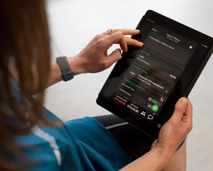 A woman using an iPad to check her blood pressure.