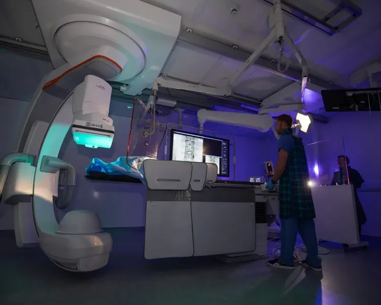 An individual standing in front of a huge mechanical device.