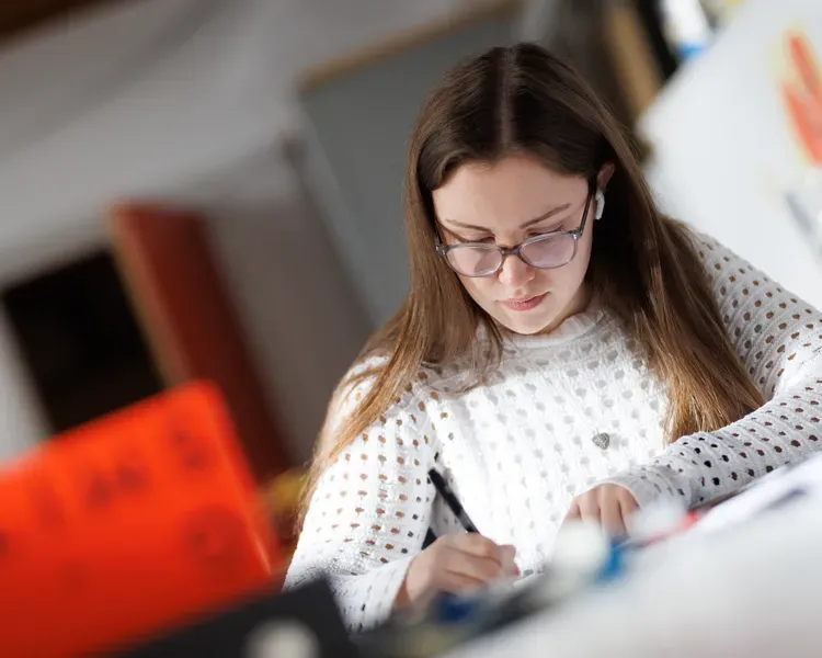 A student writing in a studio environment