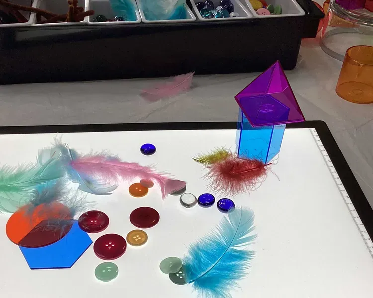 A lightbox with colourful buttons and feathers on top.