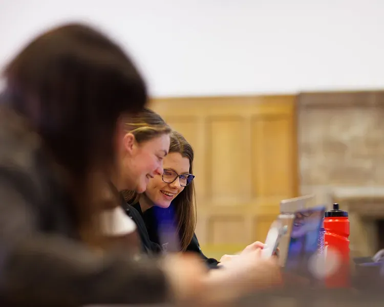 Two students looking at a laptop screen
