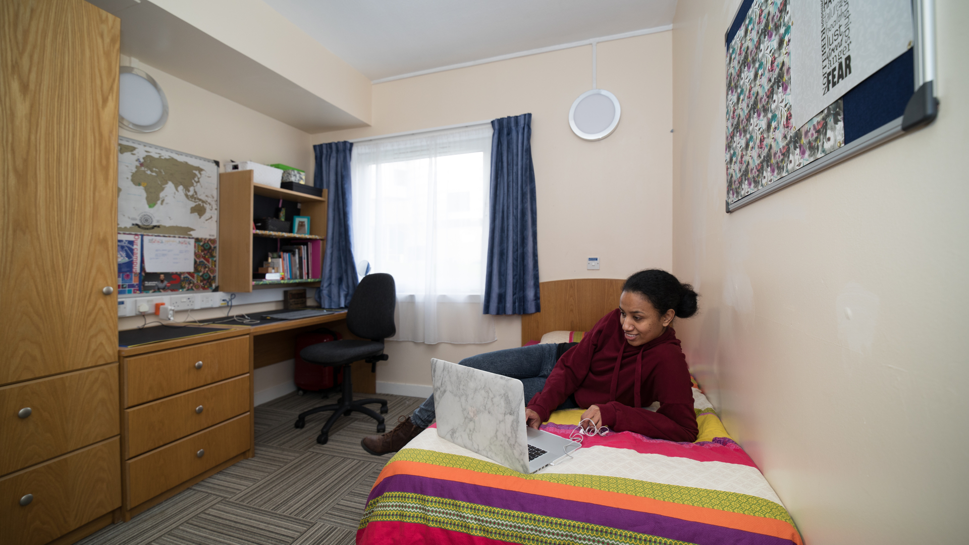 Student lying on bed in student accommodation