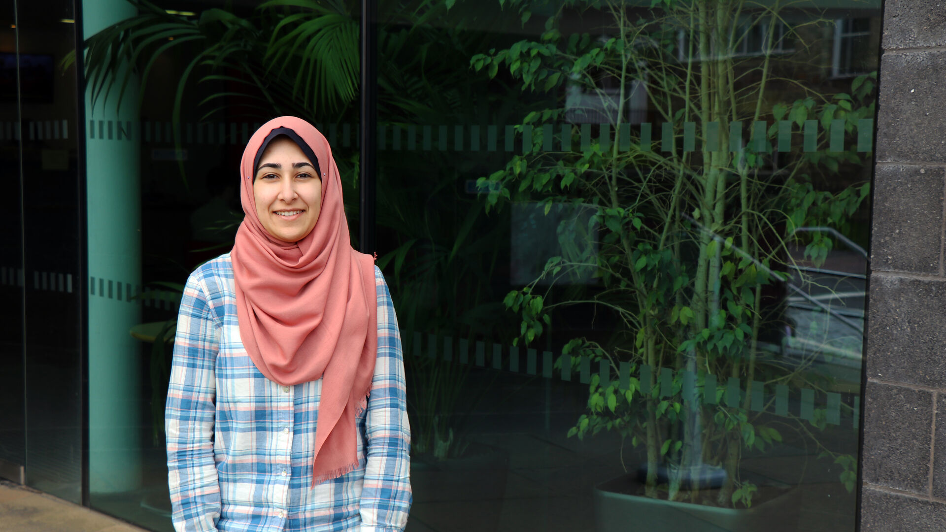 a student standing outside with plants