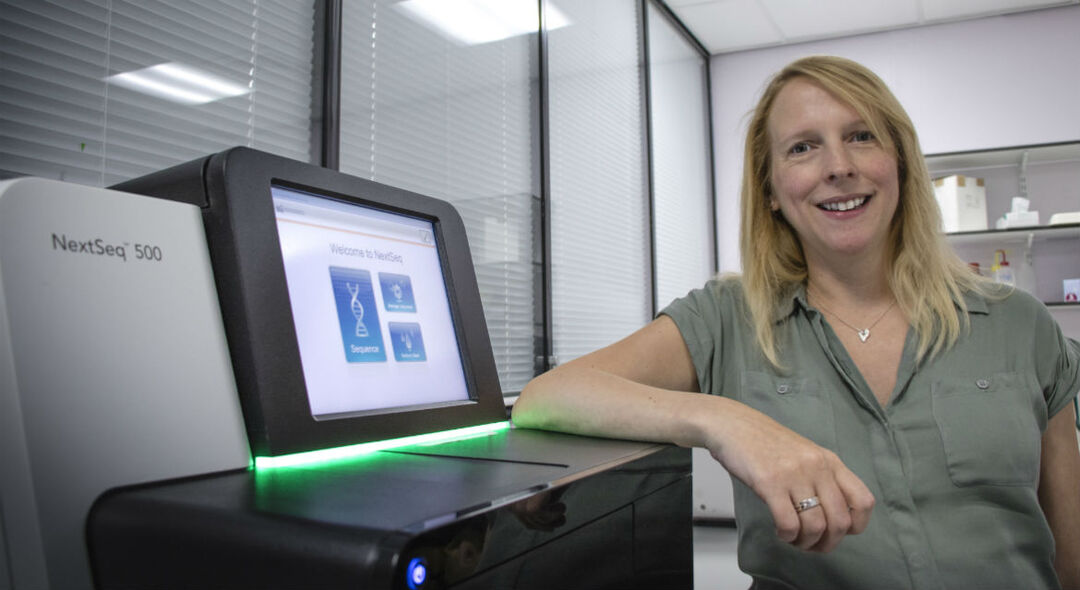 Dr Charis Marwick stands next to machine