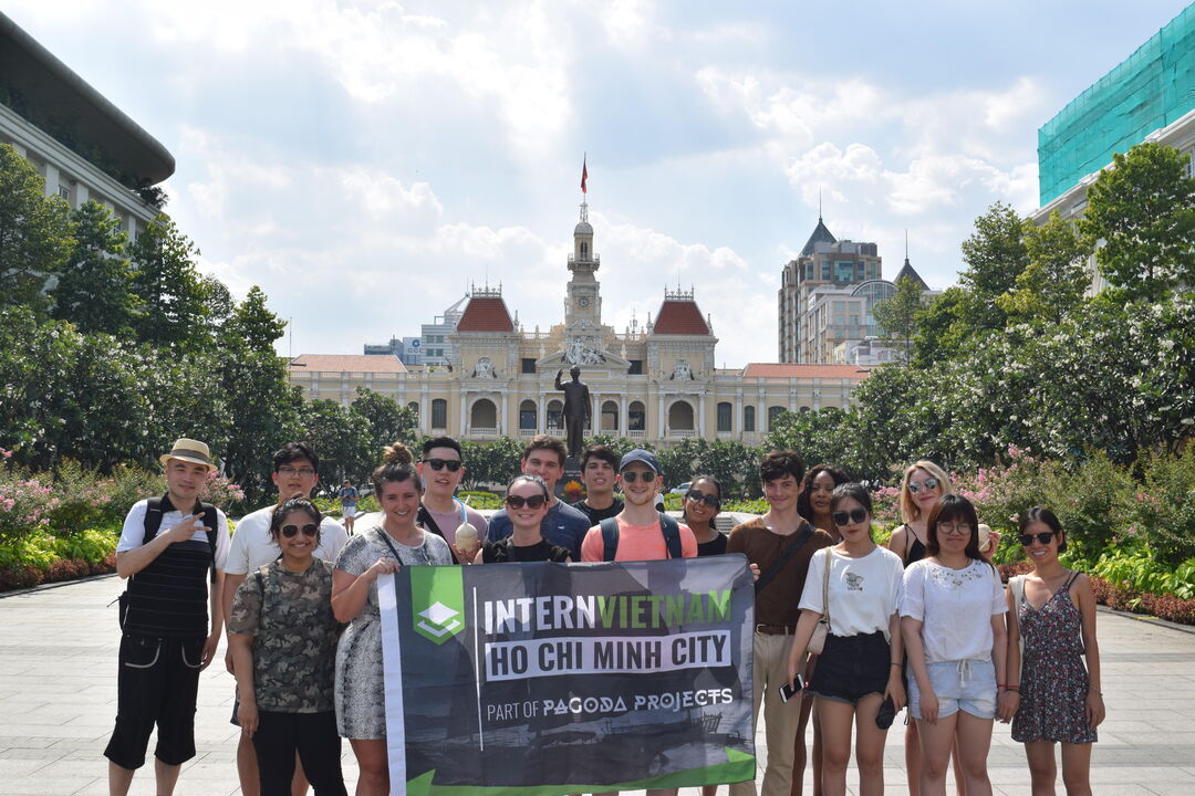 students on a global internship holding a banner