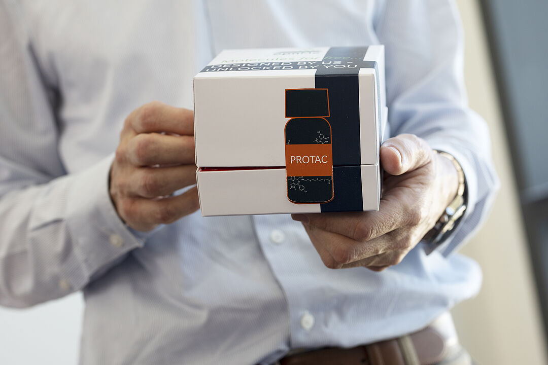 a man from the neck down holding a box