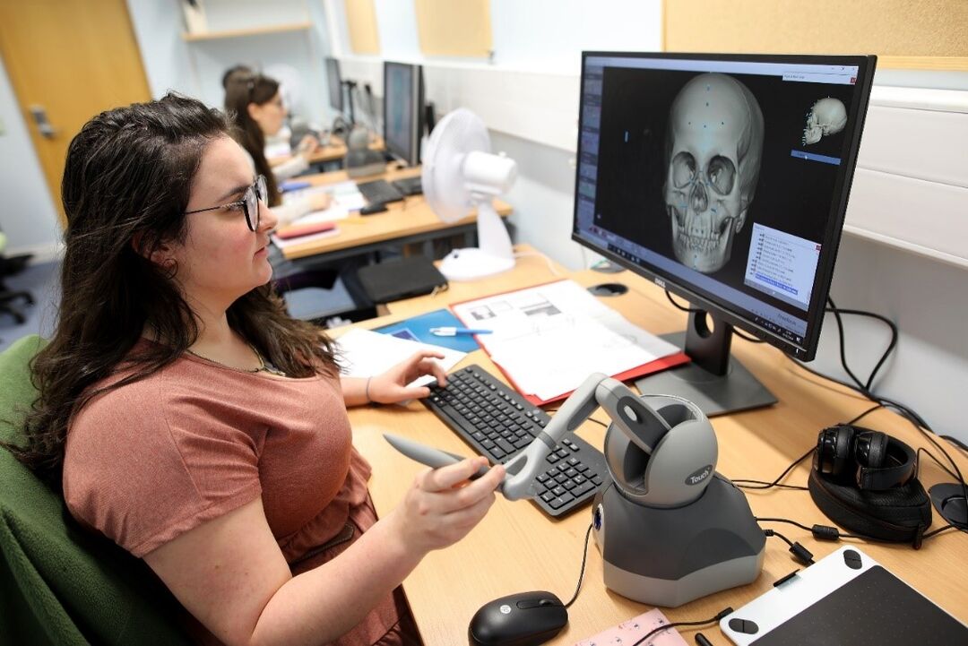 a student working on a computer creating a facial image