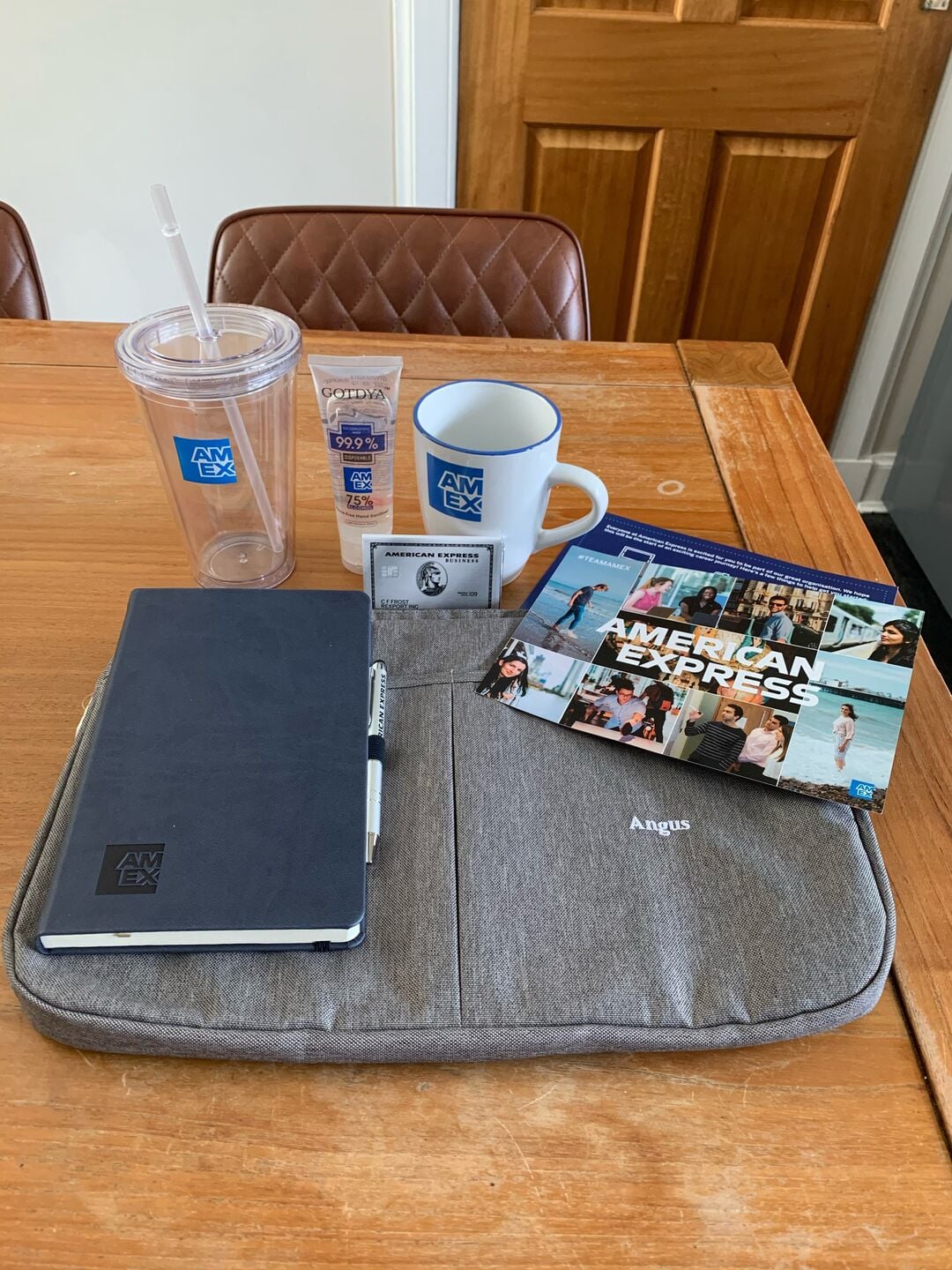 a goody bag from American express including a cup, mug, notebook and a bag