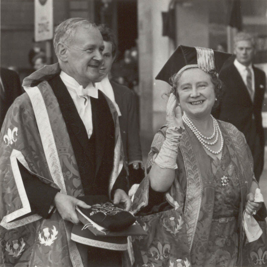 an image of the Queen Mother in 1967 waving with pearls around her neck