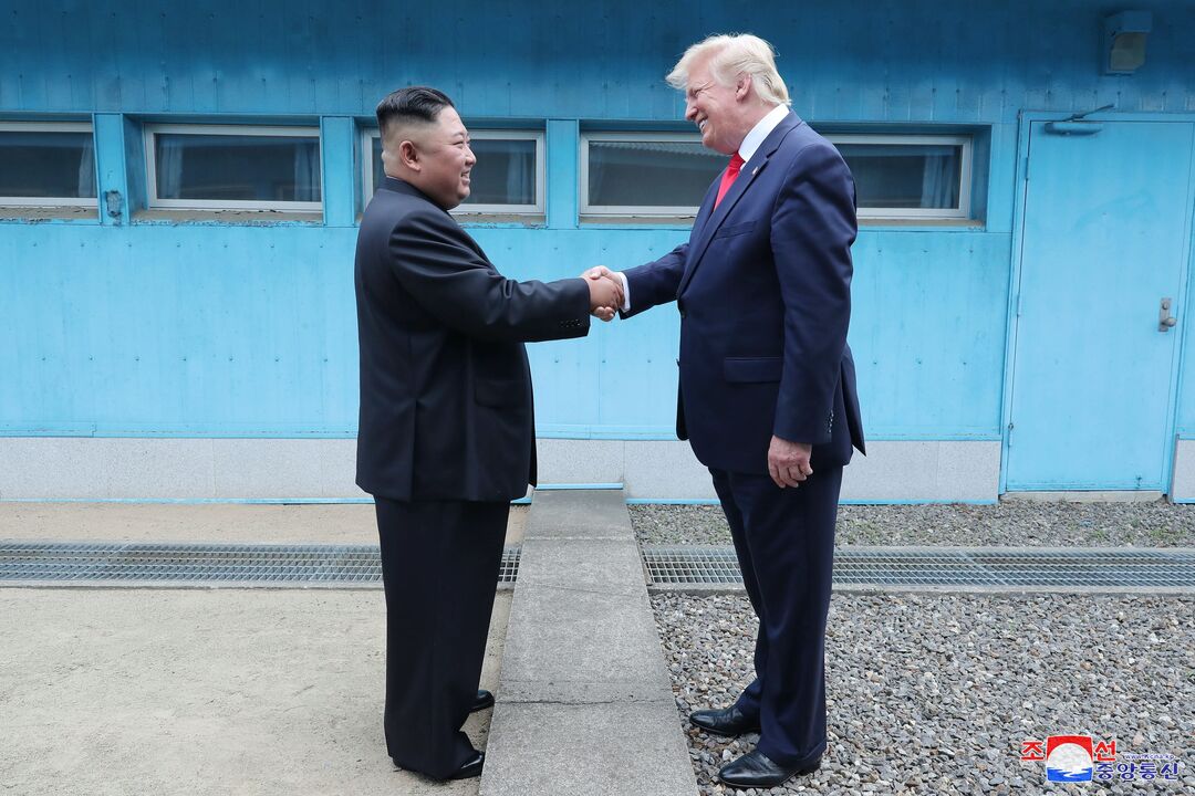 Photograph of Kim Jong Un and Donald Trump shaking hands over the North Korean / South Korean Border