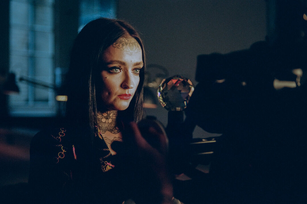 Image from behind the scenes on the set of The Dead Are Jewels To Me – Dr Maria Maclennan looking into a camera while being filmed for a close-up