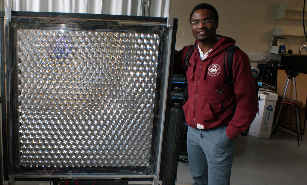 solar panel with a smiling man standing beside it