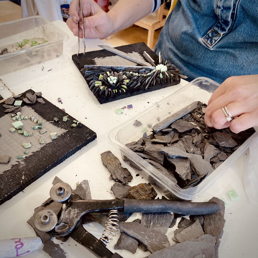 Table with mosaic art pieces spread out on the surface