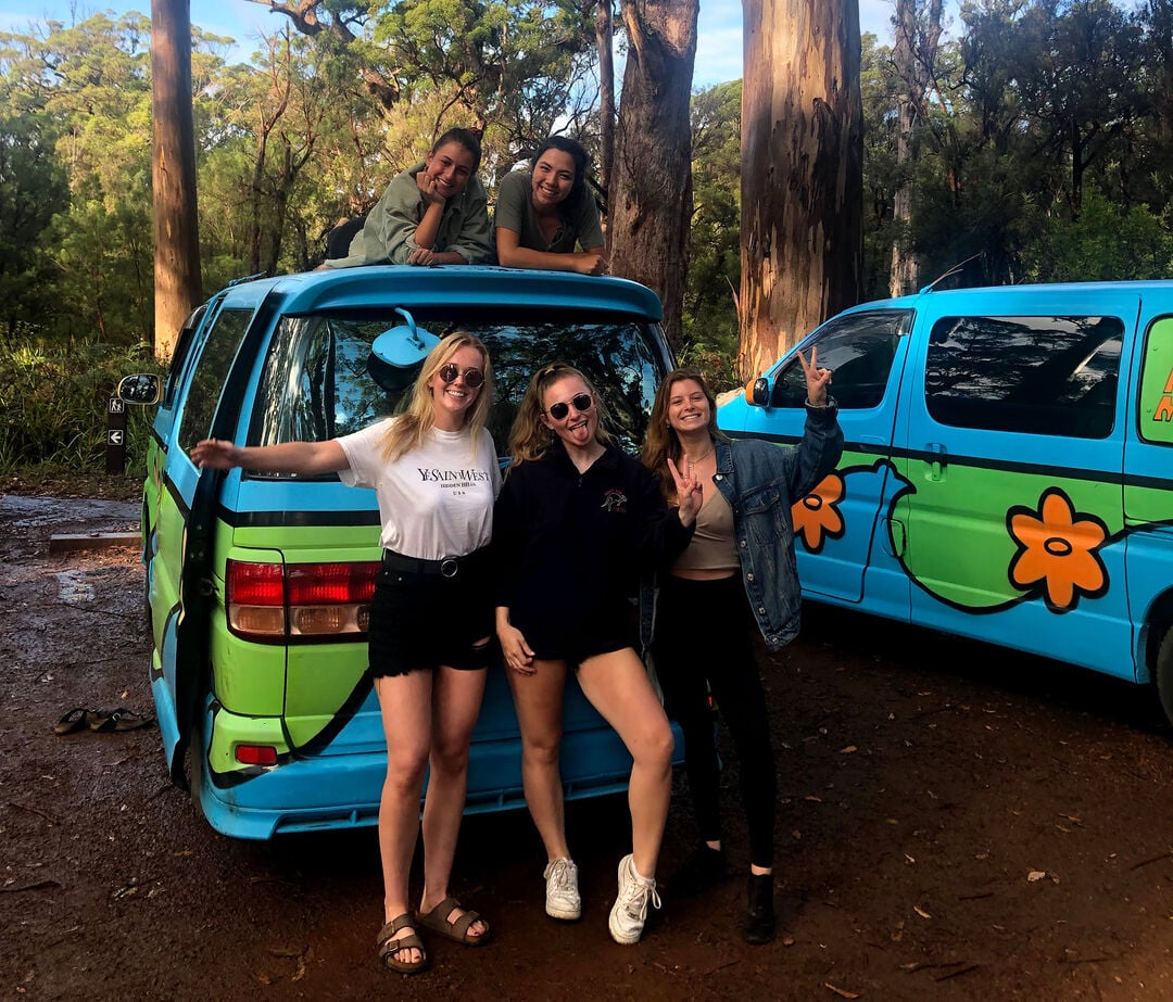 Students on study exchange posing outside van