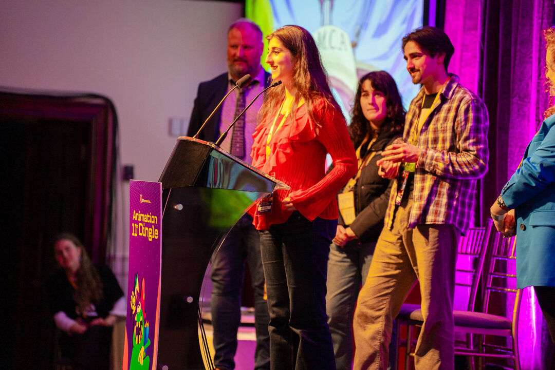 Millie Strachan standing on stage in front of a podium giving an acceptance speech