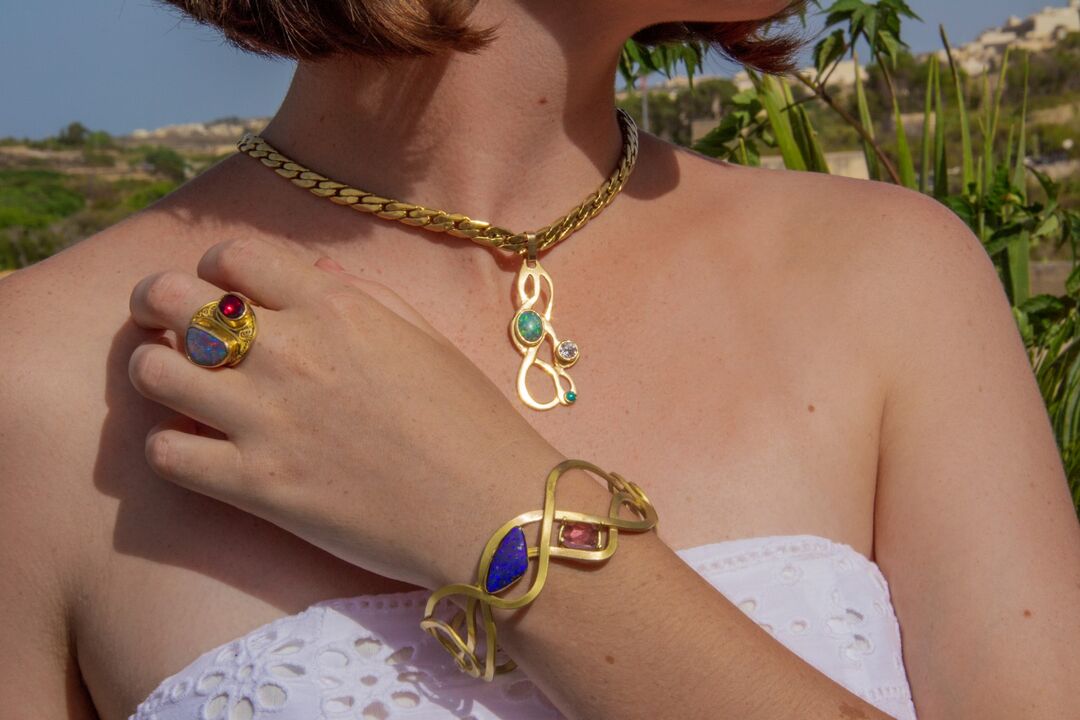Model showcasing gold necklace, bracelet, and right 