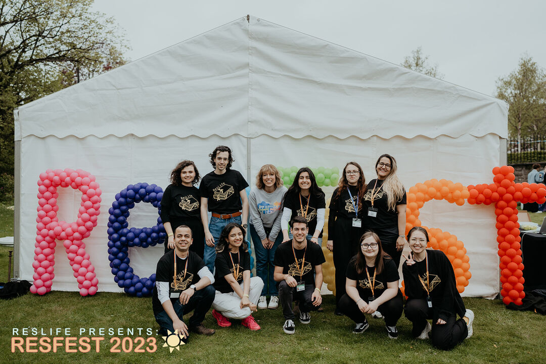 RESLife team shot in front of a white tent with colourful balloons during Welcome week