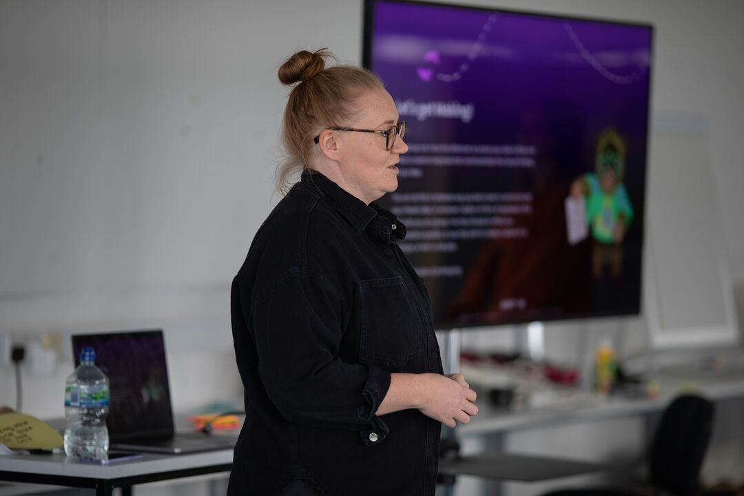 A facilitator at a DJCAD Design Sprint talking at the front of the room