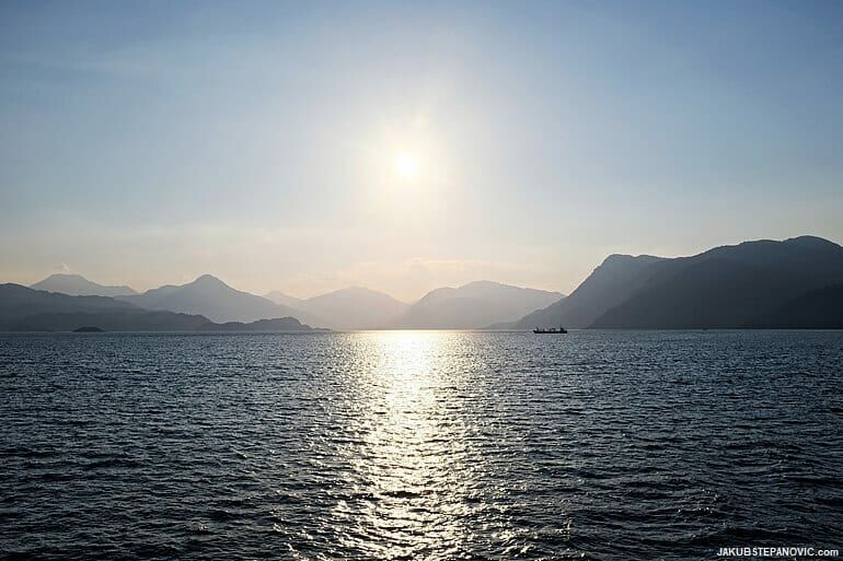 loch on a sunny day with mountains in the background
