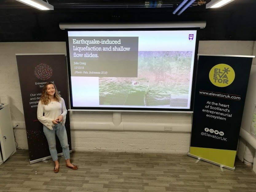 student standing in front of screen with presentation