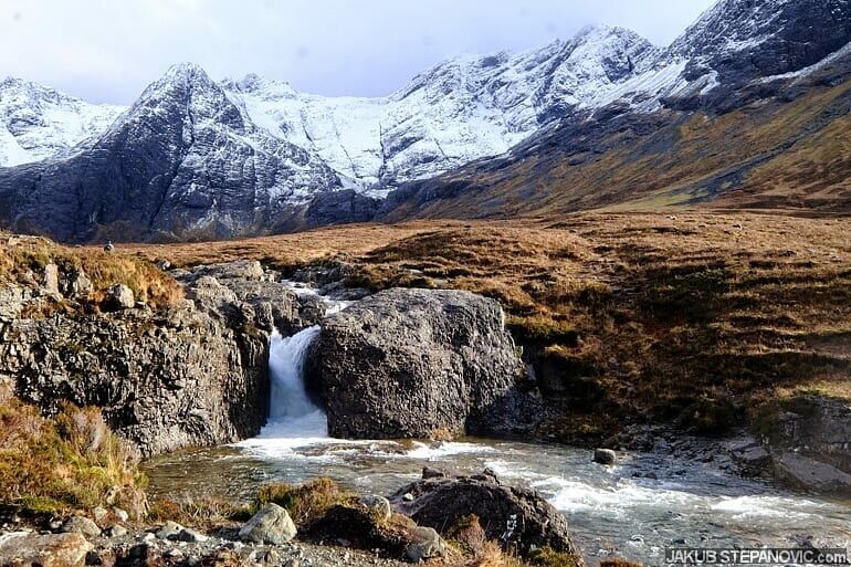 waterfall in front of mountains