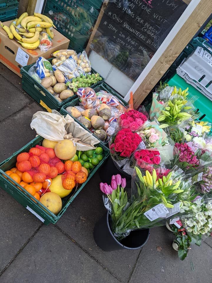 boxes of food and flowers at the community fridge