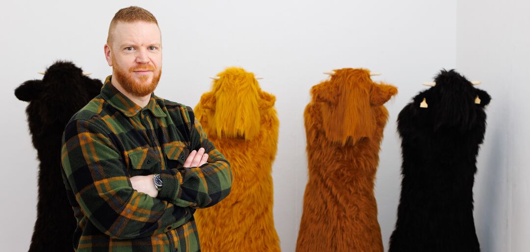 Ewan Douglas stands with his fluffy sculptures