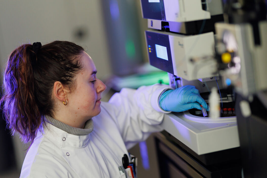 1. Female scientist in lab coat operating equipment in laboratory.