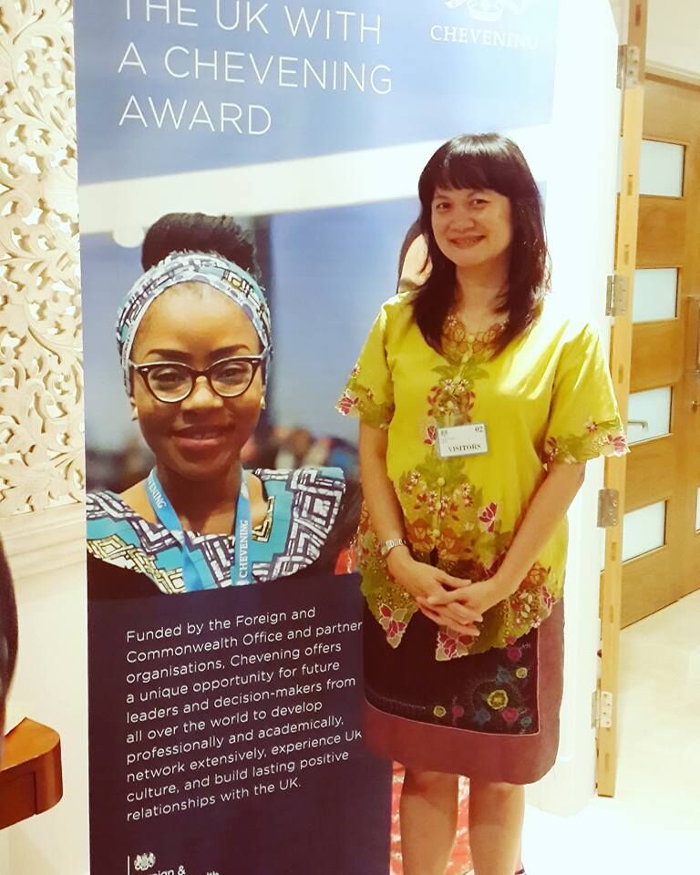 Lina standing next to a Chevening Award poster