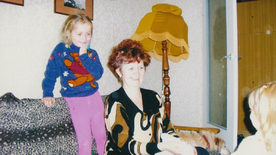 An old photograph of Justyna, her gran and her sister in her gran's living room in Poland in the early 2000's 