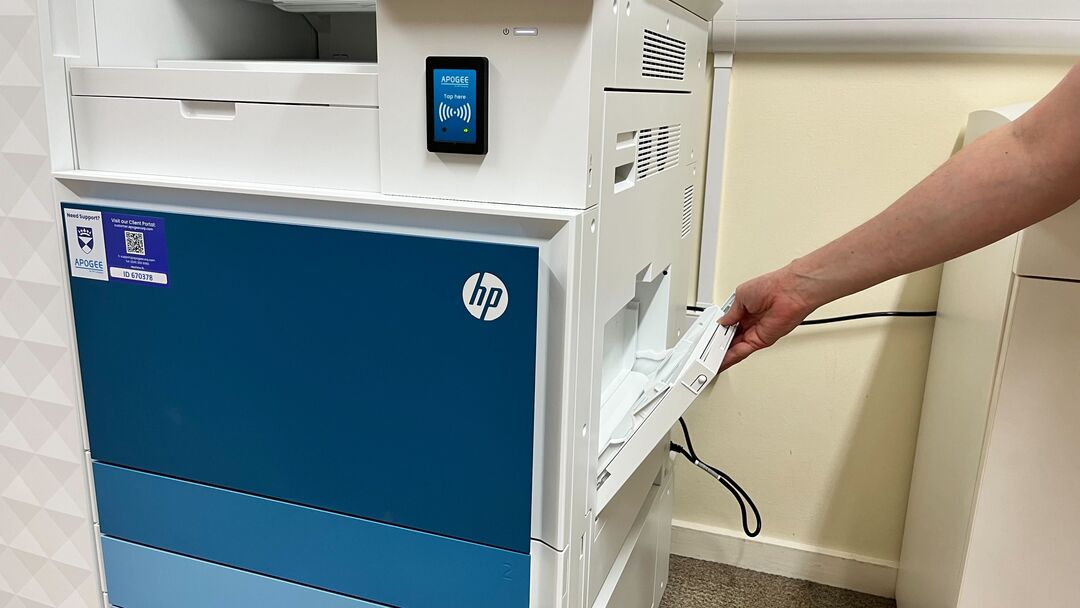 A person opening the side multi-purpose tray of the HP printer