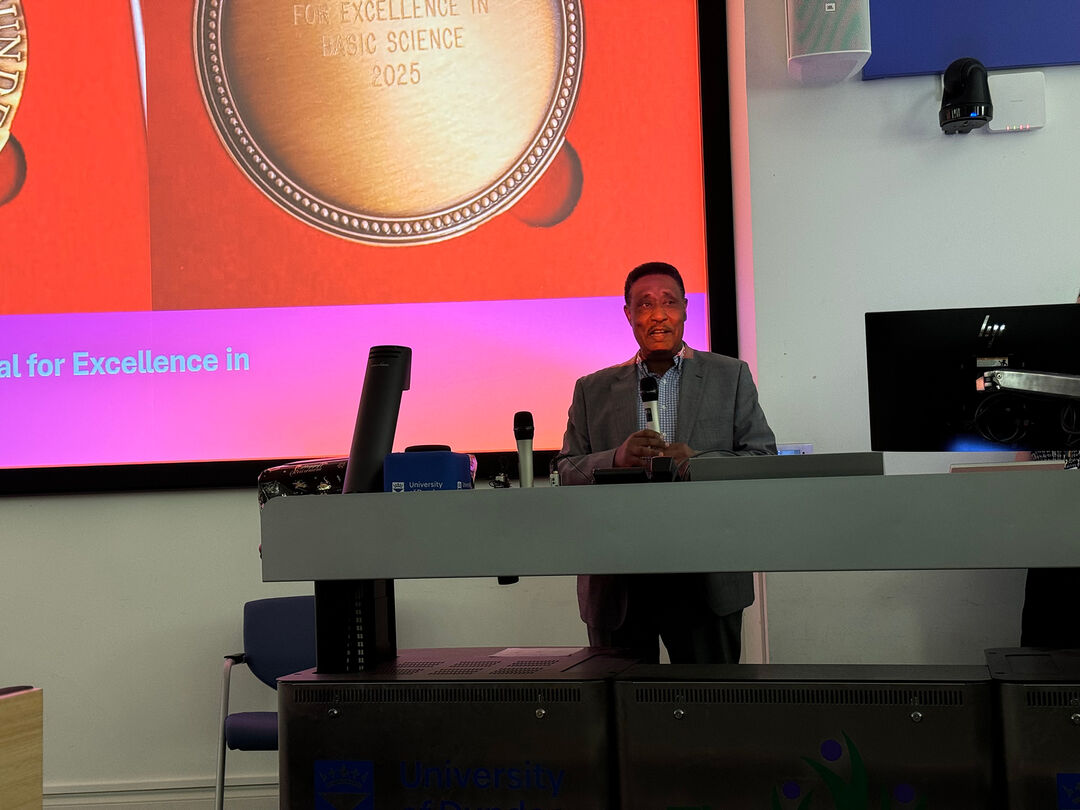 Shihab standing at a podium in a lecture theatre