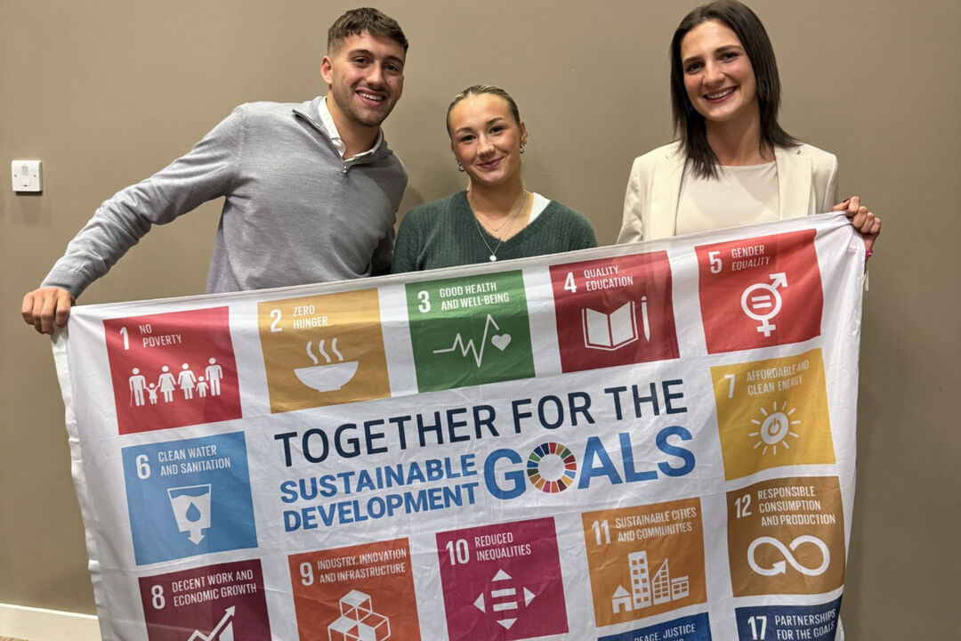 Students, Angus Williams, Megan McCarthy, Katriona Aitken holding up a banner