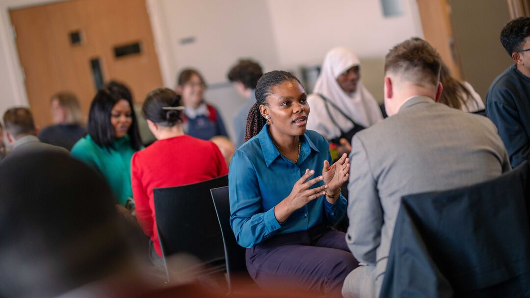 Two people sitting opposite each other at a speed interview event
