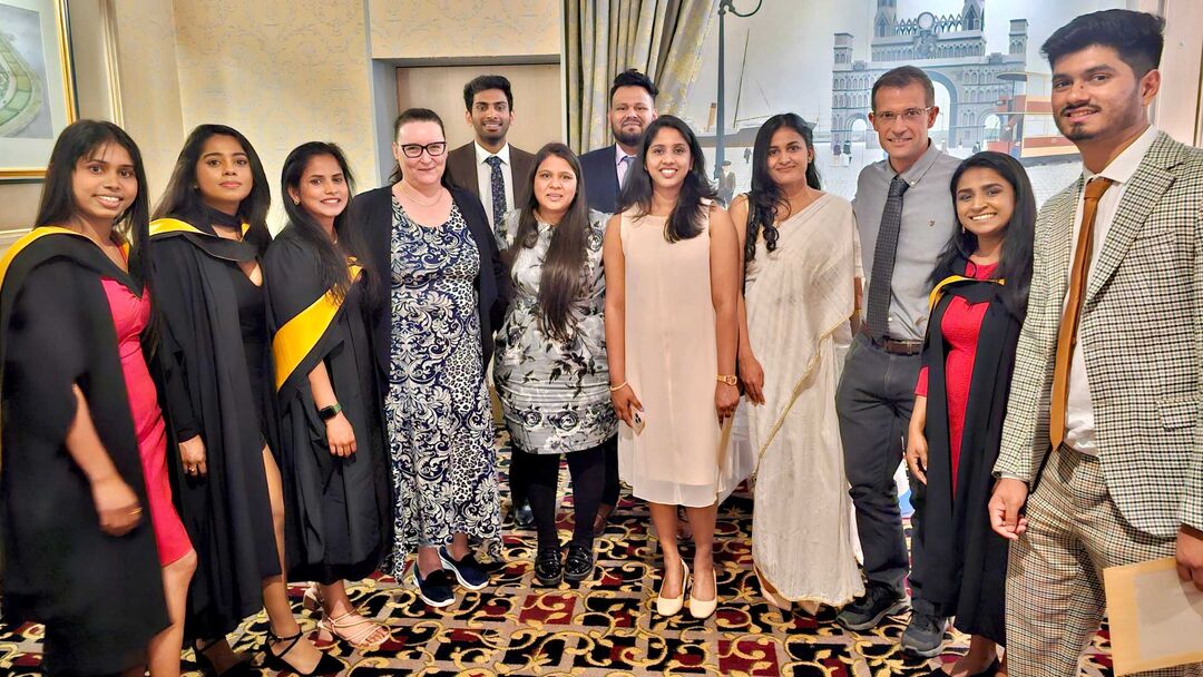 A group of people in formal clothing stand together
