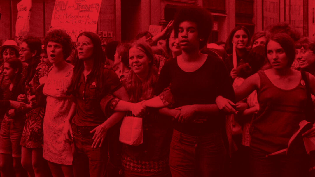 Red saturated image - a group of women stand in the street protesting arms linked