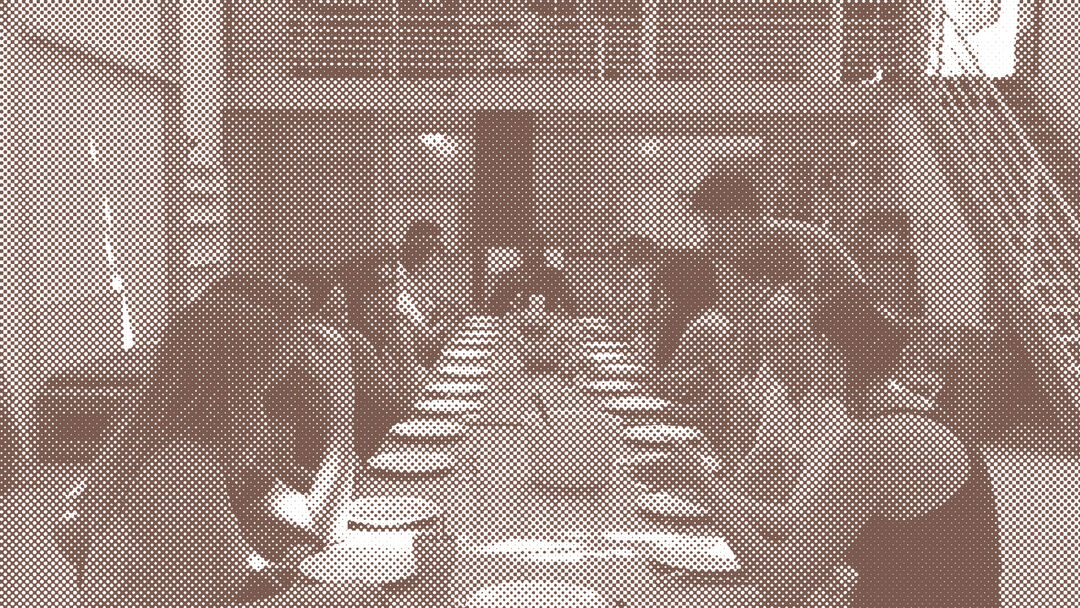 A group of people gathered eating around a long table