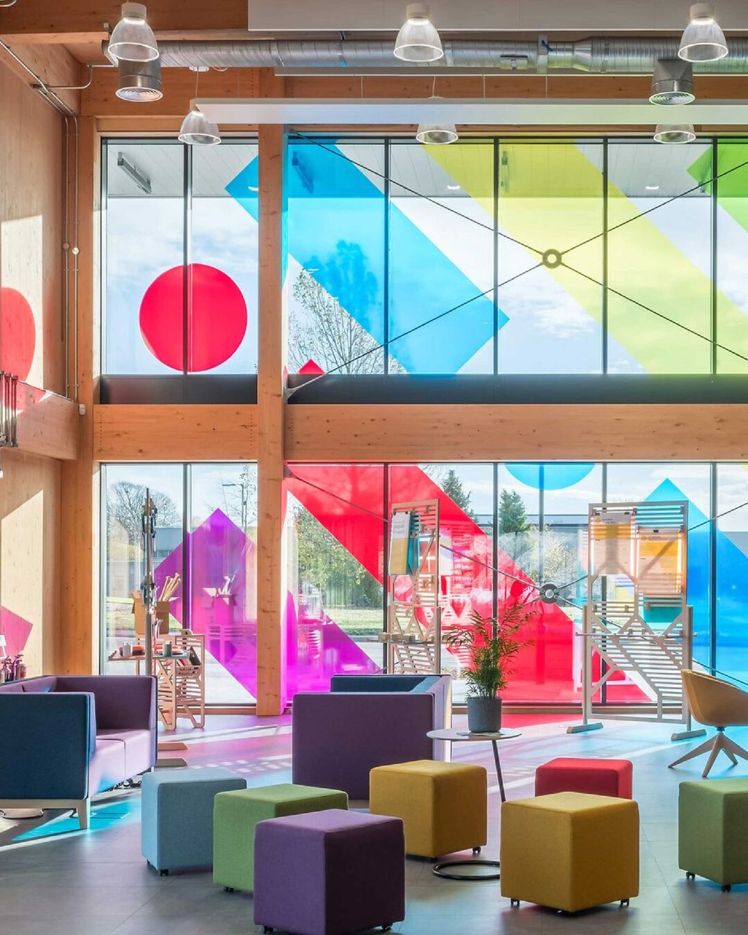 A room with floor to ceiling windows, with large colourful shapes on them.