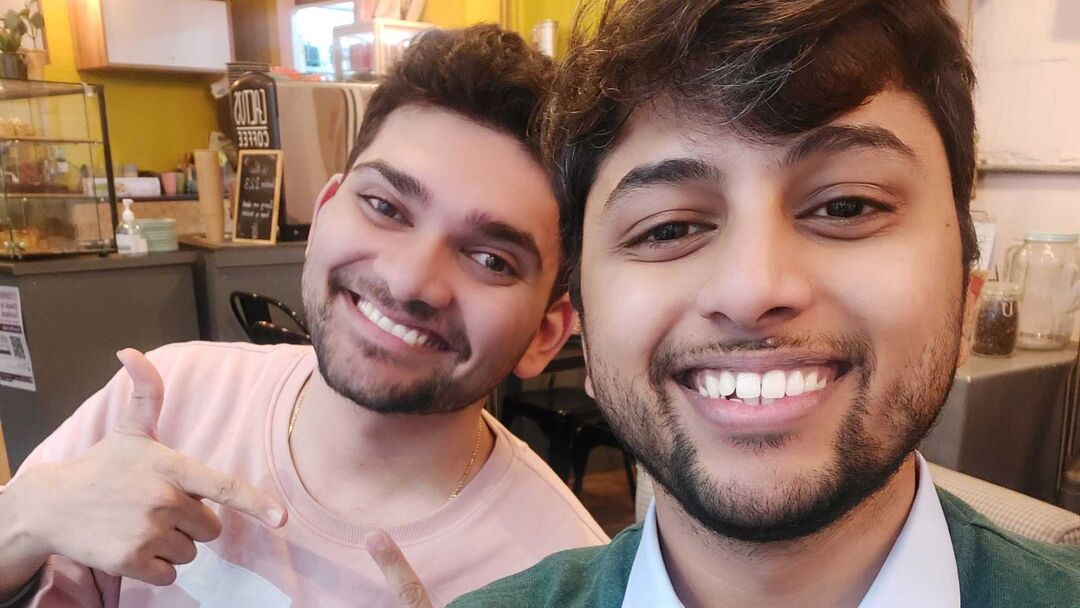 2 students taking a selfie both are smiling at the camera.