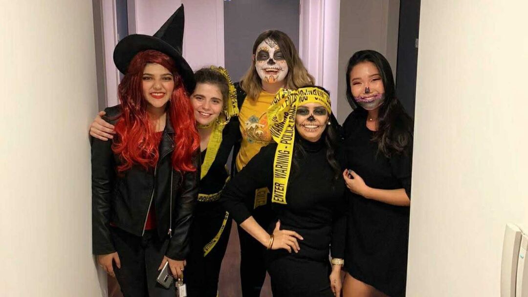 5 students smiling and posing for the camera wearing Halloween costumes.