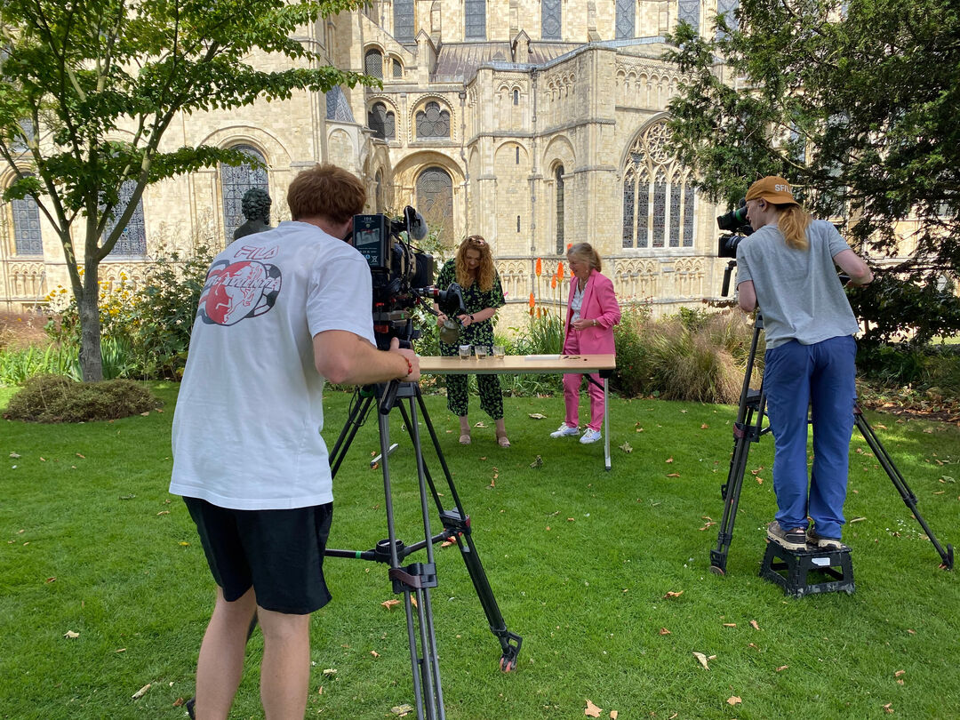 Graduate Euan McClenaghan, seen from behind, operating a camera while filming