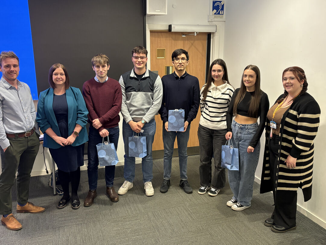 group shot of people standing together in a room