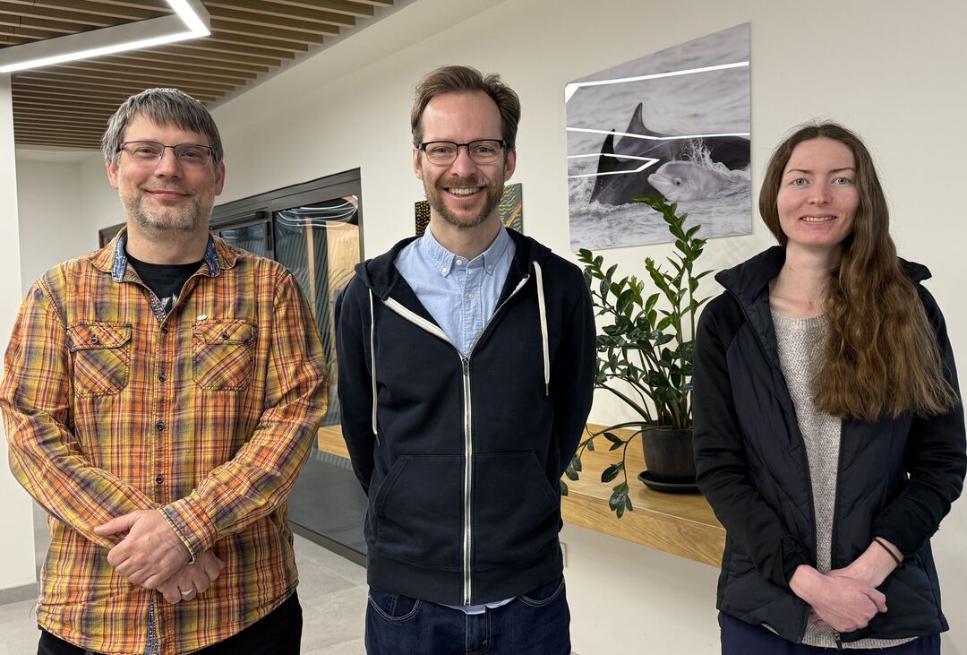 Three people stood next to each other smiling