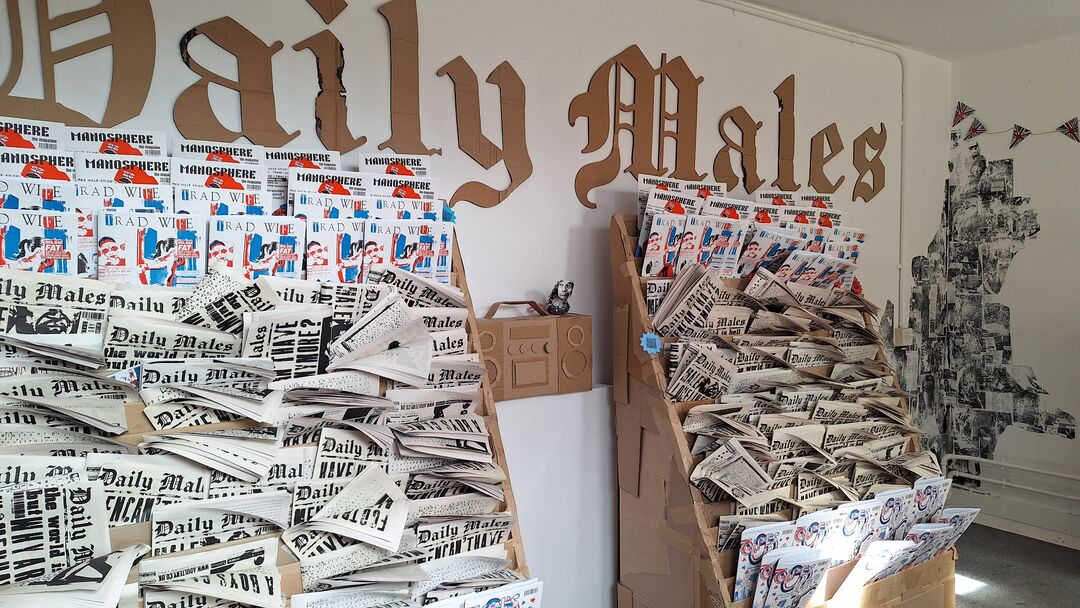 a newspaper stand filled with handmade newspapers and magazines. The stand is made from cardboard