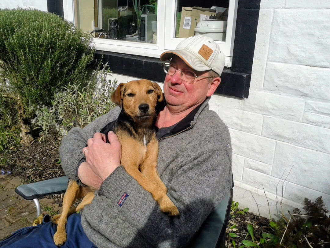 A man with a dog sat on his lap