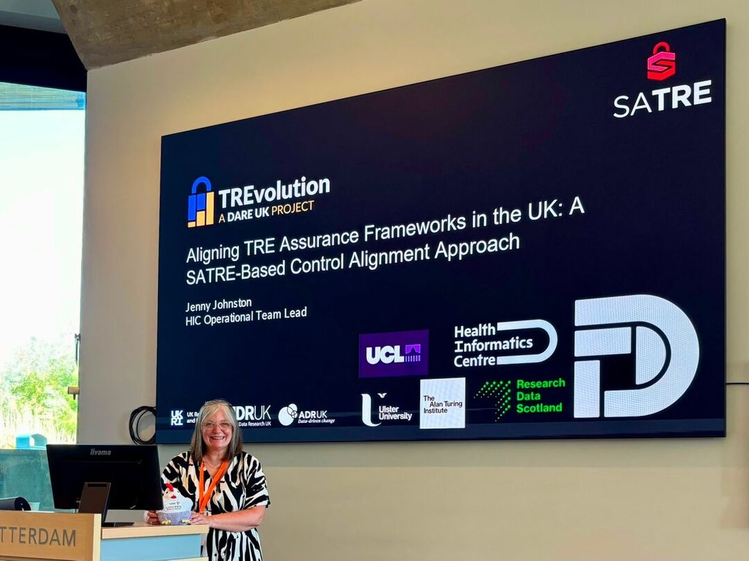 A speaker stands at a podium with a TREvolution and SATRE slide 
